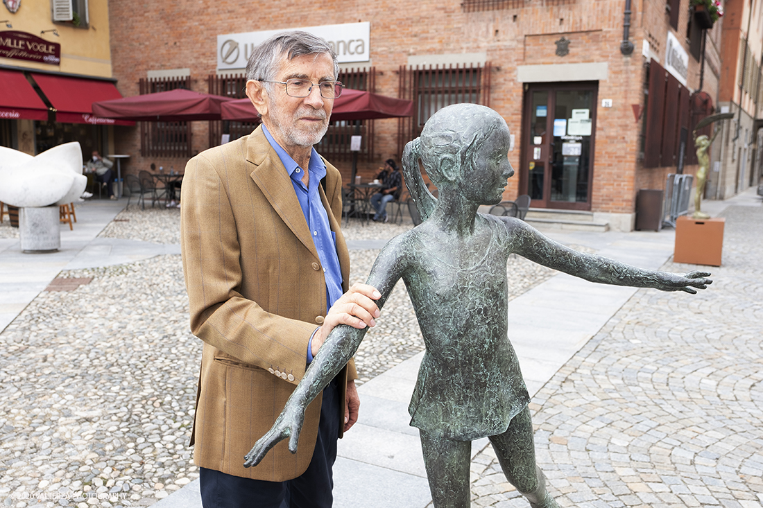 _DSF7584.jpg - 15/06/2020.  Cherasco. Anche in una cittadina come Cherasco l'Arte, la Cultura e la Storia sono una potente leva per riprendersi dal lockdown. Due mostre di scultori, un grande maestro come Sergio Unia e la brava emergente Lisena Aresu sono le leve della ripartenza del turismo a Cherasco che ha  un centro storico caratterizzato da notevoli monumenti e palazzi del passato. Nella foto il maestro Sergio Unia con una sua opera esposta nella piazzetta antistante il municipio.