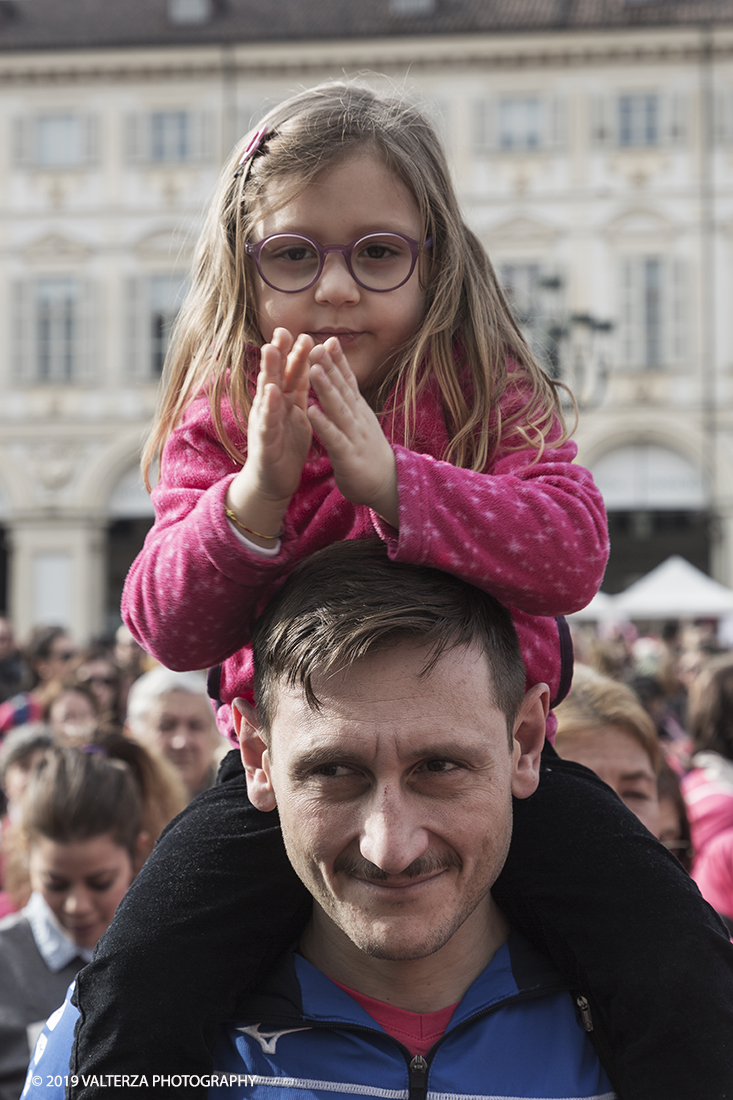 _X9B6410.jpg - 03-03-2019. Torino. â€œJust The Woman I am â€� Ã¨ una corsa/camminata podistica non competitiva di 6 km per sostenere la ricerca universitaria sul cancro: uomini e donne correranno fianco a fianco a sostegno della ricerca universitaria e della diffusione di una maggiore consapevolezza di sÃ© per un corretto stile di vita.  In questa giornata non c'Ã¨ solo la corsa, ma anche un fitto programma di eventi in piazza, non esclusivamente sportivi. Nella foto giovanissima spettarice applaude le esibizioni sul palco.