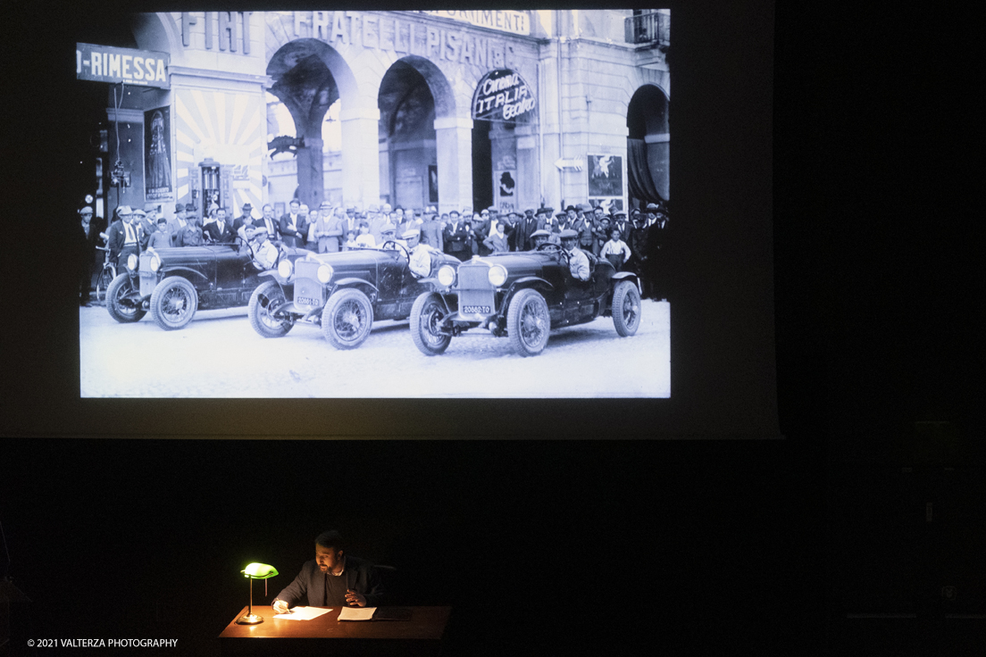 _DSF5725.jpg - 26/10/2021. Torino. Una mostra fotografica con le immagini del fotografo Adriano Scoffone racconta gli anni â€˜20 e â€˜30 della Provincia Granda e gli audaci piloti della Cuneo - Colle della Maddalena Nuvolari, Varzi, Campari e diversi altri. Nella foto mentre vengono proiettate alcune delle 80 immagini costituentti la mostra l'attore Paolo Giangrasso legge una immaginaria lettera scritta da Varzi alla mogglie carolina