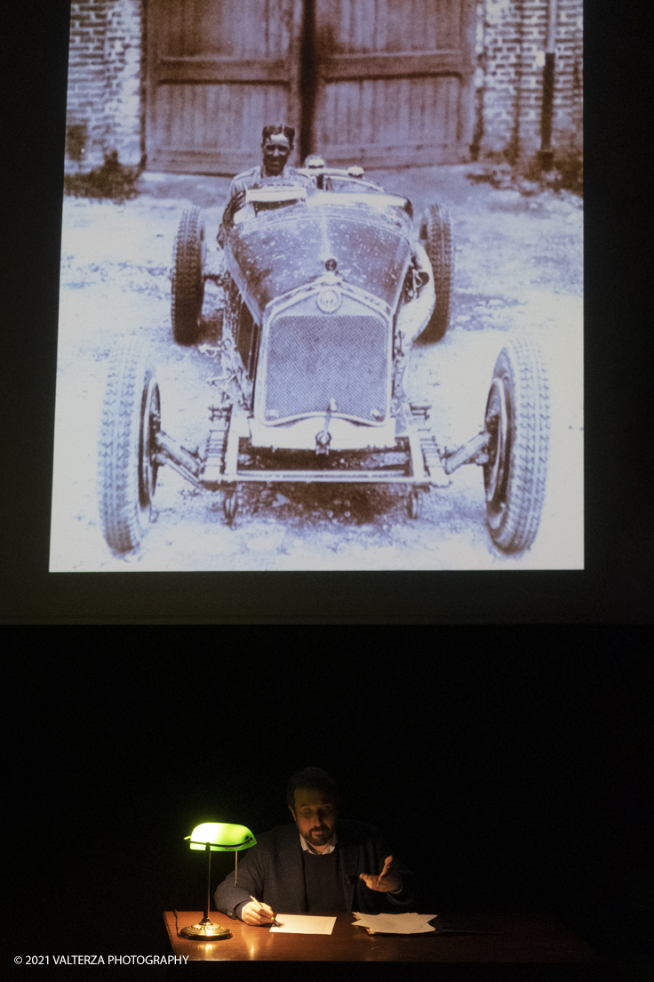 _DSF5748.jpg - 26/10/2021. Torino. Una mostra fotografica con le immagini del fotografo Adriano Scoffone racconta gli anni â€˜20 e â€˜30 della Provincia Granda e gli audaci piloti della Cuneo - Colle della Maddalena Nuvolari, Varzi, Campari e diversi altri. Nella foto mentre vengono proiettate alcune delle 80 immagini costituentti la mostra l'attore Paolo Giangrasso legge una immaginaria lettera scritta da Varzi alla mogglie carolina