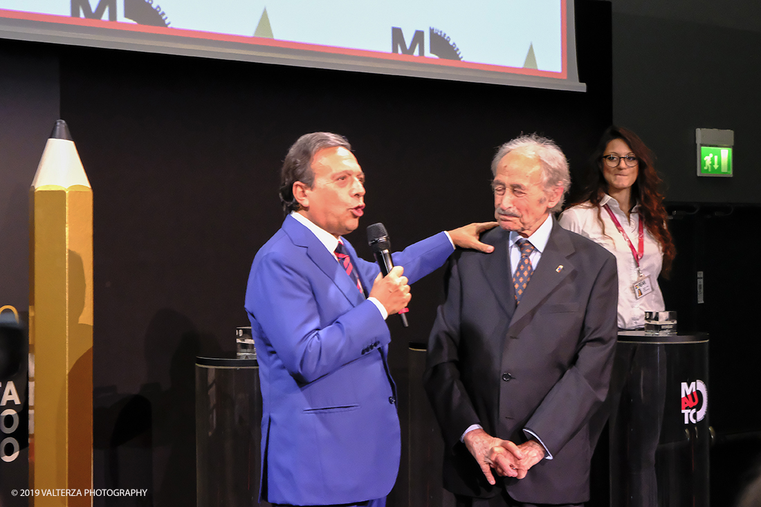 _DSF1271.jpg - 15/10/2019. Torino. Matita d'oro 2019. Anche quest'anno il Mauto ha assegnato i suoi prestigiosi premi al mondo dell'automobile. Nella foto Piero Chiambretti prima della cermonia si intrattiene sul palco con Aldo Brovarone storico designer torinese dell'Auto