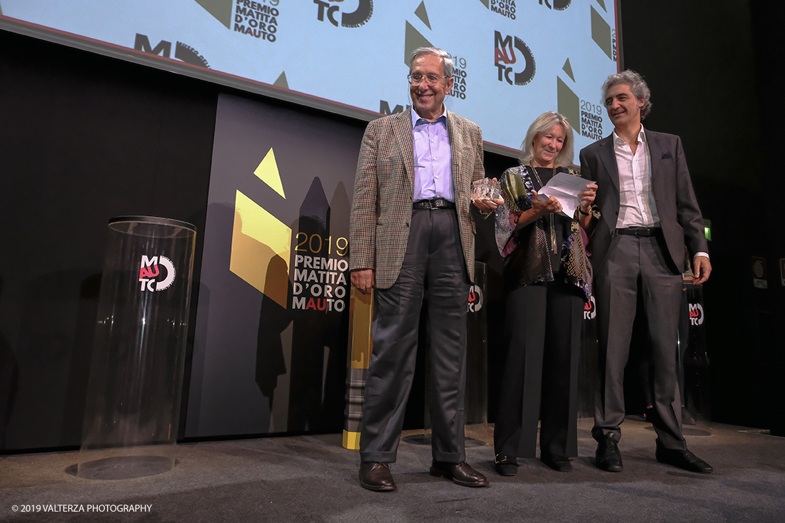 _DSF1546.jpg - 15/10/2019. Torino. Matita d'oro 2019. Anche quest'anno il Mauto ha assegnato i suoi prestigiosi premi al mondo dell'automobile. Nella foto Il premio MAUTO â€œCarlo Biscaretti di Ruffiaâ€� va allâ€™ Ing Mauro Forghieri  lâ€™insuperabile creativitÃ  ingegneristica e gli straordinari successi ottenuti su strada e su pista: durante gli anni in cui Ã¨ stato Direttore Tecnico della Scuderia Ferrari. Consegnano il premio  Mariella Mengozzi e Benedetto Camerana.