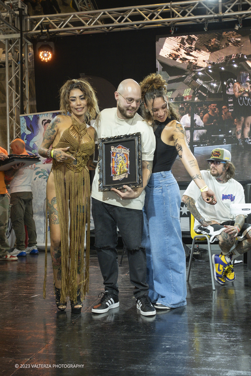 _DSF7923.jpg - 23/09/2023. Torino. Torino Tattoo Convention torna in grande stile in una prestigiosa location e un selezionato parterre di artisti tatuatori e spettacoli per intrattenere il pubblico. Nella foto la premiazione della categoria Others Styles, i terzi classificati, tatuatore Andrea Infranto di 24 tattoo studio e la tatuata Chiara