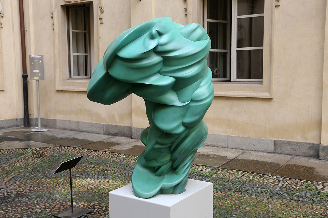 ArteAlleCorti_012.jpg - Tony CRAGG - Tommy - Palazzo Civico L’opera di Tony Cragg è focalizzata sulle molteplici relazioni esistenti tra l’essere umano e il suo ambiente.Usufruendo di un’ampia selezione di materiali e di tecniche scultoree l’artista tematizza la complessaconnessione tra la fi gura (vedi opera esposta “Tommy”), l’oggetto (“Digital Skin”) e il paesaggio che, per Cragg,include sia sistemi geologici e microbiologici che contesti urbani e industriali (“Rod”).