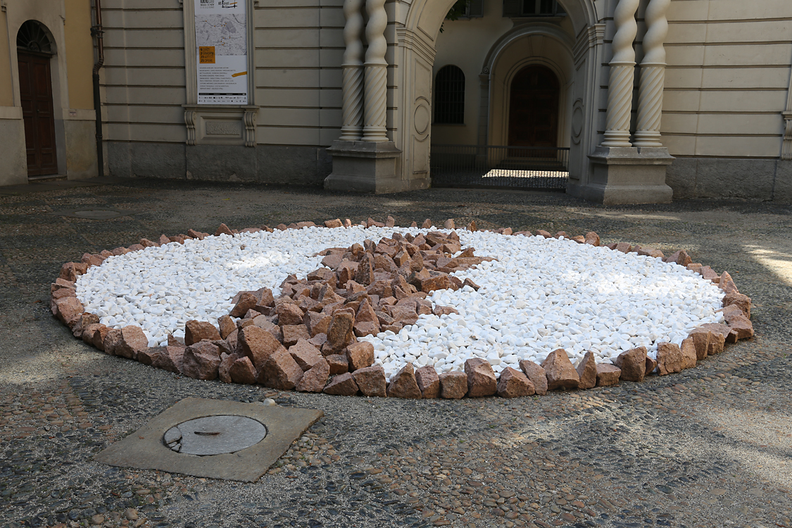 ArteAlleCorti_065.jpg - Richard LONG - Blu Sky Circle - Palazzo Asinari di San Marzano Fare arte camminando e organizzando in forme geometriche gli elementi della natura si può considerare da unlato come un autoritratto dell’artista e dall’altro come autoritratto della storia dell’uomo. L’artista realizza le propriesculture utilizzando elementi semplici quali pietre, legni e fango. Le sue opere appartengono ad ogni luogo dellaterra, spazi aperti nel territorio o spazi progettati dall’uomo.