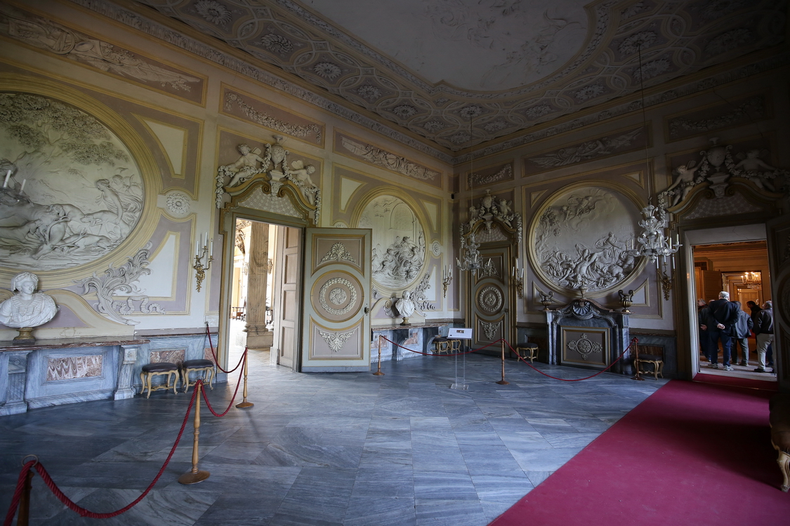 CastelloRacconigi_031.JPG - La Sala di Diana   opera settecentesca dell'architetto Giovanni Battista Bórra (1757), ai tempi di Carlo Alberto era l'ingresso di rappresentanza del Castello.  La sala prende il nome dai sei medaglioni in stucco, opera di Giuseppe Bolina, raffiguranti scene del Mito di Diana, dea della caccia e sorella di Apollo ed è il risultato di una contaminazione fra lo stile del nuovo classicismo e le esperienze in campo archeologico del suo progettista. 