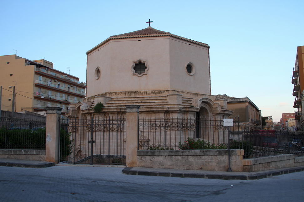 Sicilia_206.JPG - Cappella del sepolcro di Santa Lucia,edificio che in epoca barocca l'architetto Giovanni Vermexio scavò nel terreno in modo che, sfondando la parete delle catacombe, il sepolcro della santa si presentasse inglobato in un muro. Il sepolcro  oggi è vuoto. Le reliquie furono infatti asportate dal generale bizantino Giorgio Maniace, durante la sua effimera (durò solo fino al 1043) liberazione di Siracusa dagli arabi, nel 1040. Maniace s'impadronì della reliquia e la inviò in dono all'imperatrice a Costantinopoli, da dove non sarebbe più tornata. Infatti i veneziani, saccheggiando la capitale bizantina durante la Quarta Crociata del 1204, se ne impadronirono a loro volta e la portarono nella propria città, dove si trova ancor oggi (nella chiesa dei santi Geremia e Lucia), nonostante i tentativi compiuti dai siracusani per ottenerne la restituzione.  