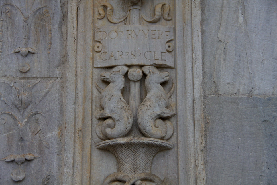 Nuvole_025.JPG - Torino - Duomo - Sculture raffiguranti animali mitologici sulla decorazione a lato del portone principale con il cartiglio del costruttore: RUVERE ° CAR ° S.CLE