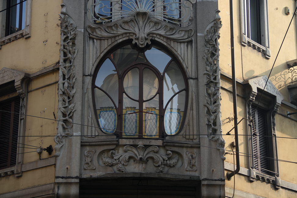 Nuvole_139.JPG - Torino - Via S. Francesco d'Assisi - Balconcino liberty con finestrone circolare decorato ai lati con intrecci di foglie.