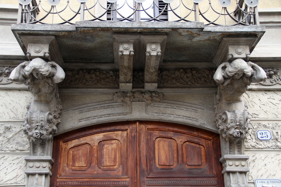 Nuvole_282.JPG - Torino - Via Federico Campana - Cariatidi a mezzo busto con braccia sopra il collo e il corpo che termina in volute e ornamenti floreali.