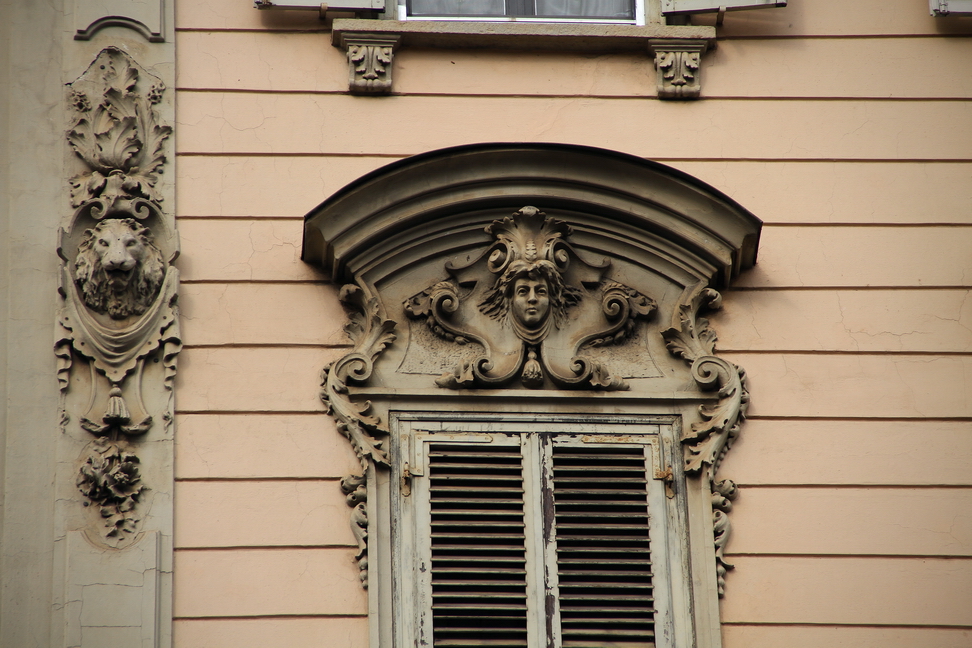 Nuvole_288.JPG - Torino - Via Madama Cristina - Soprafinestra con volto femminile, a lato decoro con testa di leone trs drappi e ornamenti floreali.