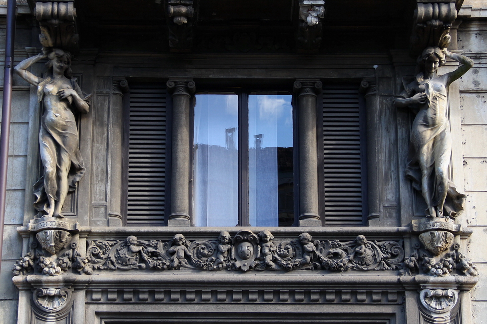 Nuvole_433.JPG - Torino - Corso Re Umberto - Cariatidi a corpo intero con svolazzante mantello semitrasparente che scende fino ai piedi. Una bella cornice con amorini impreziosisce il balcone.