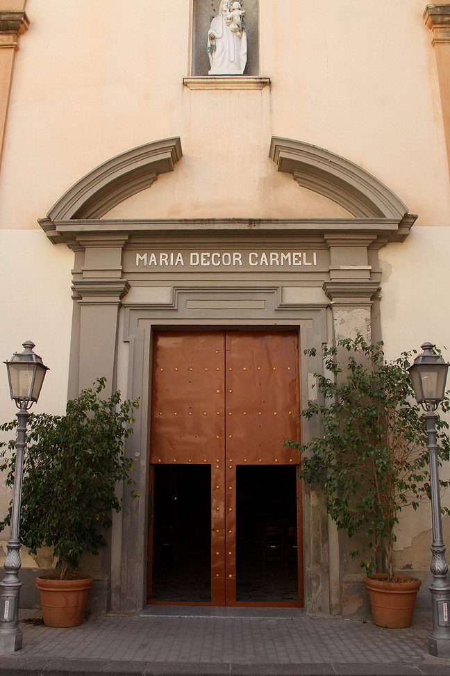 Sicilia_036.JPG - il portale d'ingresso presenta una struttura in pietra lavica formata da due pilastri che sorreggono un semplice arco spezzato sotto cui vi è l'iscrizione in latino che recita la frase "Mater Decor Carmeli"...