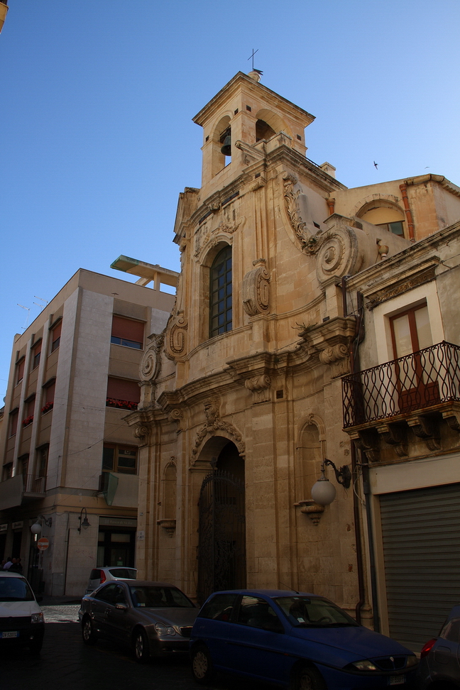 Sicilia_055.JPG - poco distante si apre la facciata della Chiesa delle Anime Sante... elegante prospetto convesso, adorno di nicchie, è arricchito da una cancellata in ferro battuto, nel suo battente è raffigurato un serpente sormontato da una croce, simbologia che esalta la vittoria del bene sul male.