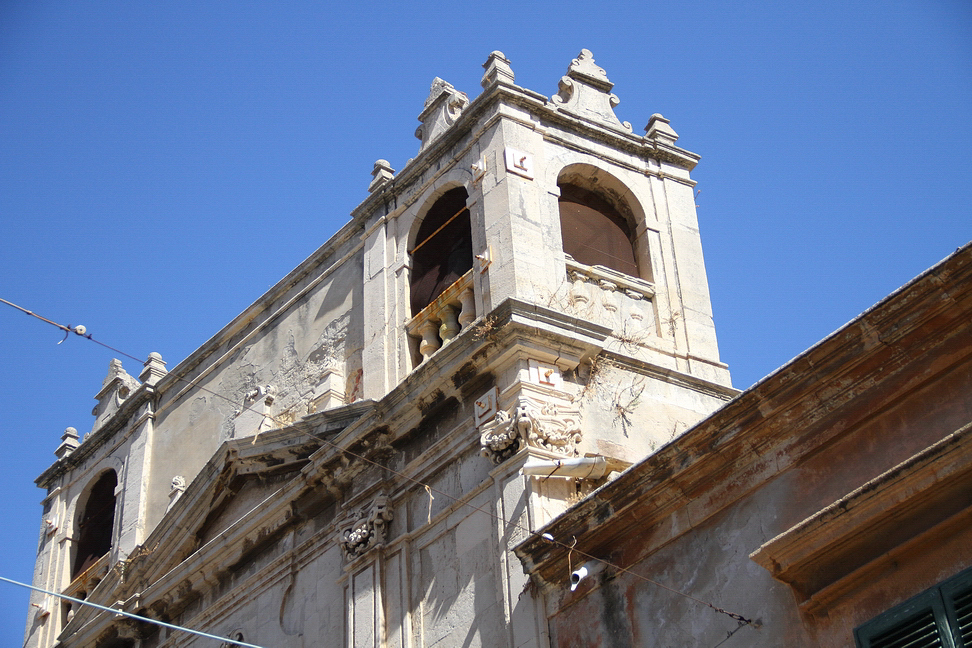 Sicilia_081.JPG - Nelle due parti laterali, in rispondenza delle parti cieche del prospetto, la costruzione presenta due piccole cellette campanarie quadrate, terminanti con trabeazione adorna di piccoli merli che ricordano il giglio fiorentino, e si alternano con delle piccole antefisse disposte ai quattro angoli...