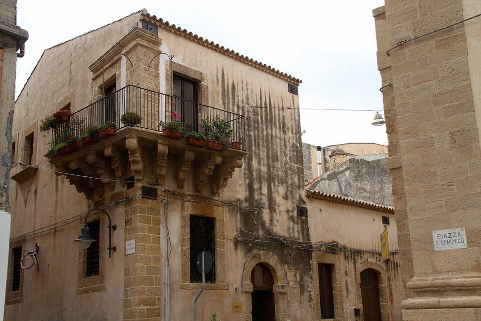 Sicilia_203.JPG - balconi fioriti retti da braccia che si tendono sulla via...