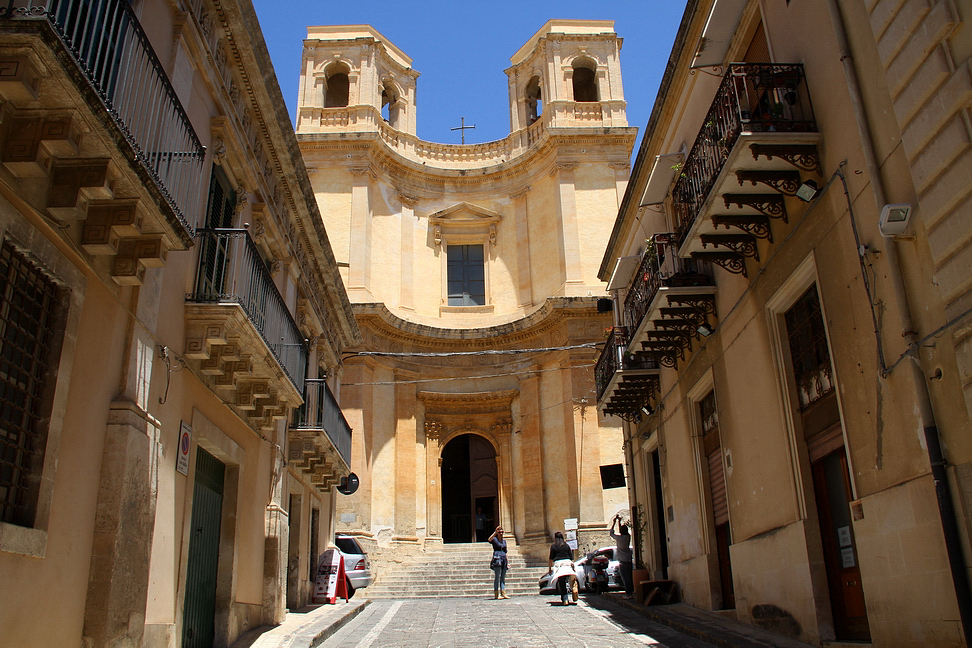 Sicilia_462.JPG - e in alto, a chiudere come un sipario Via Nicolaci ( la via dell'infiorata), si affaccia la meravigliosa facciata della Chiesa di Montevergini, attribuita a Vincenzo Sinatra (1748). Ha prospetto concavo con due torri campanarie...